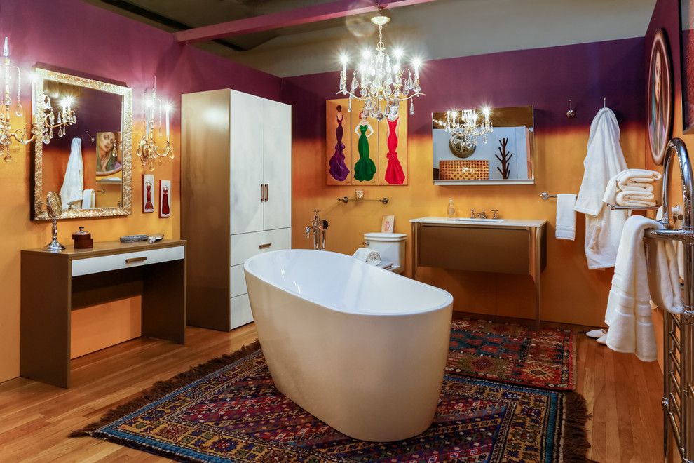 Mittelgroßes Stilmix Duschbad mit flächenbündigen Schrankfronten, beigen Schränken, freistehender Badewanne, Toilette mit Aufsatzspülkasten, braunen Fliesen, lila Wandfarbe, hellem Holzboden, Unterbauwaschbecken und Quarzit-Waschtisch in New York