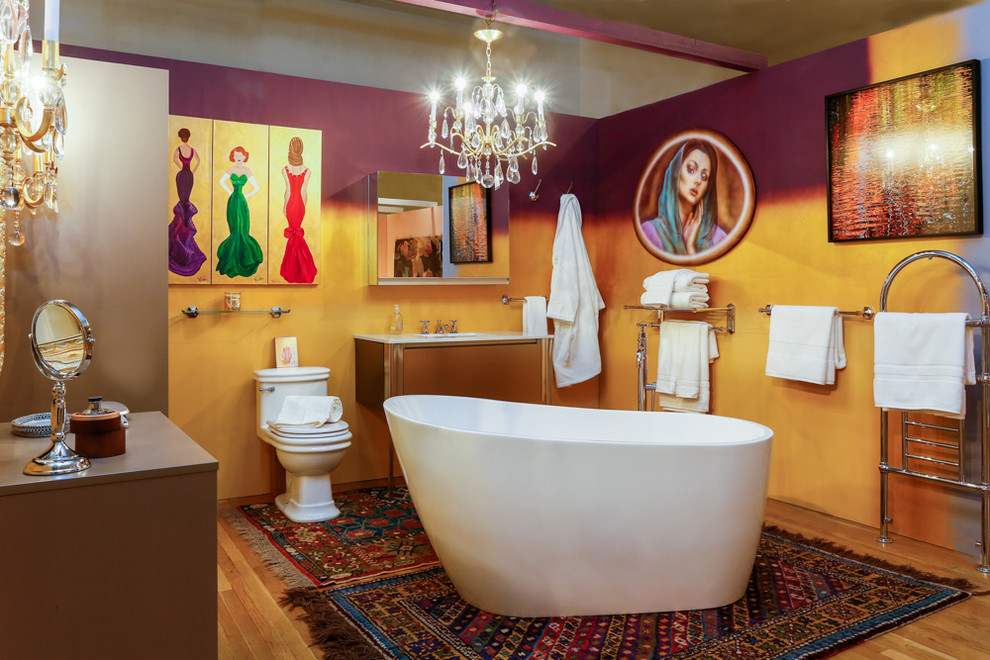 ニューヨークにあるお手頃価格の中くらいなおしゃれなバスルーム (浴槽なし) (フラットパネル扉のキャビネット、ベージュのキャビネット、置き型浴槽、一体型トイレ	、茶色いタイル、紫の壁、淡色無垢フローリング、アンダーカウンター洗面器、珪岩の洗面台) の写真