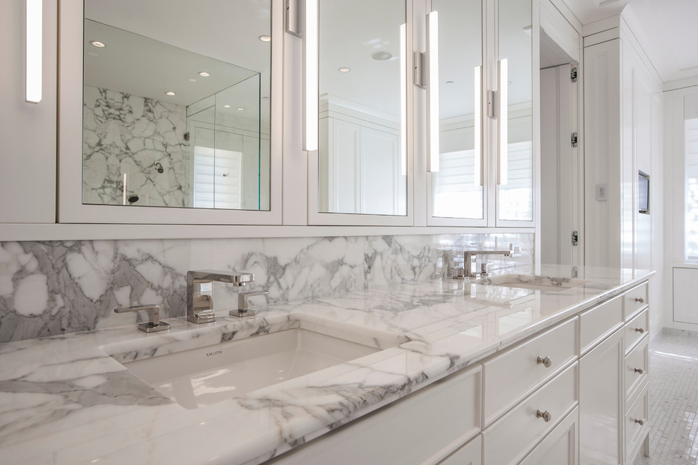Diseño de cuarto de baño principal tradicional renovado grande con puertas de armario blancas, encimera de mármol, baldosas y/o azulejos blancos y paredes blancas