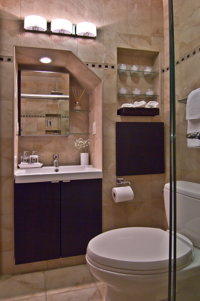 Example of a small trendy beige tile and ceramic tile porcelain tile alcove shower design in New York with an integrated sink, flat-panel cabinets, dark wood cabinets, solid surface countertops, a two-piece toilet and beige walls