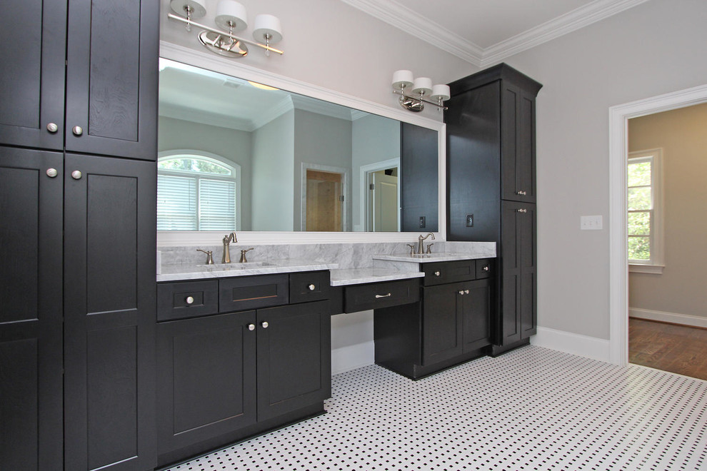 Inredning av ett klassiskt stort en-suite badrum, med ett undermonterad handfat, luckor med infälld panel, skåp i mörkt trä, marmorbänkskiva, ett fristående badkar, en dusch i en alkov och grå väggar