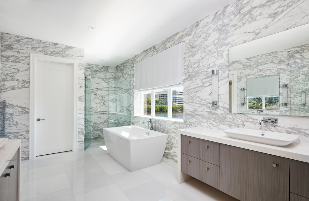 Exempel på ett stort modernt en-suite badrum, med skåp i mellenmörkt trä, ett fristående badkar, en dusch i en alkov, vit kakel, stenkakel, marmorgolv, ett fristående handfat, träbänkskiva, grå väggar och vitt golv