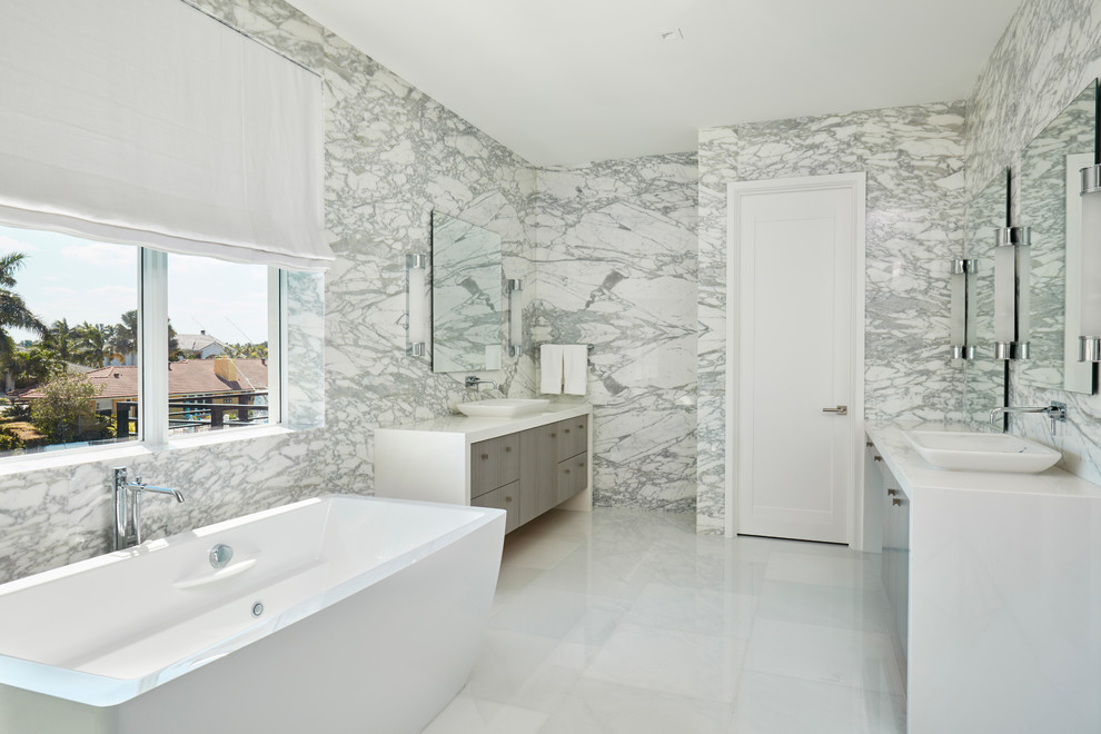 Réalisation d'une grande douche en alcôve principale design en bois brun avec une baignoire indépendante, un carrelage blanc, un carrelage de pierre, un sol en marbre, une vasque, un plan de toilette en bois et un sol blanc.