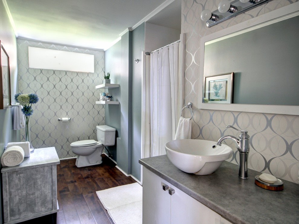 Exempel på ett mellanstort modernt badrum med dusch, med ett fristående handfat, släta luckor, vita skåp, laminatbänkskiva, en dusch i en alkov, en toalettstol med separat cisternkåpa, vita väggar och mörkt trägolv