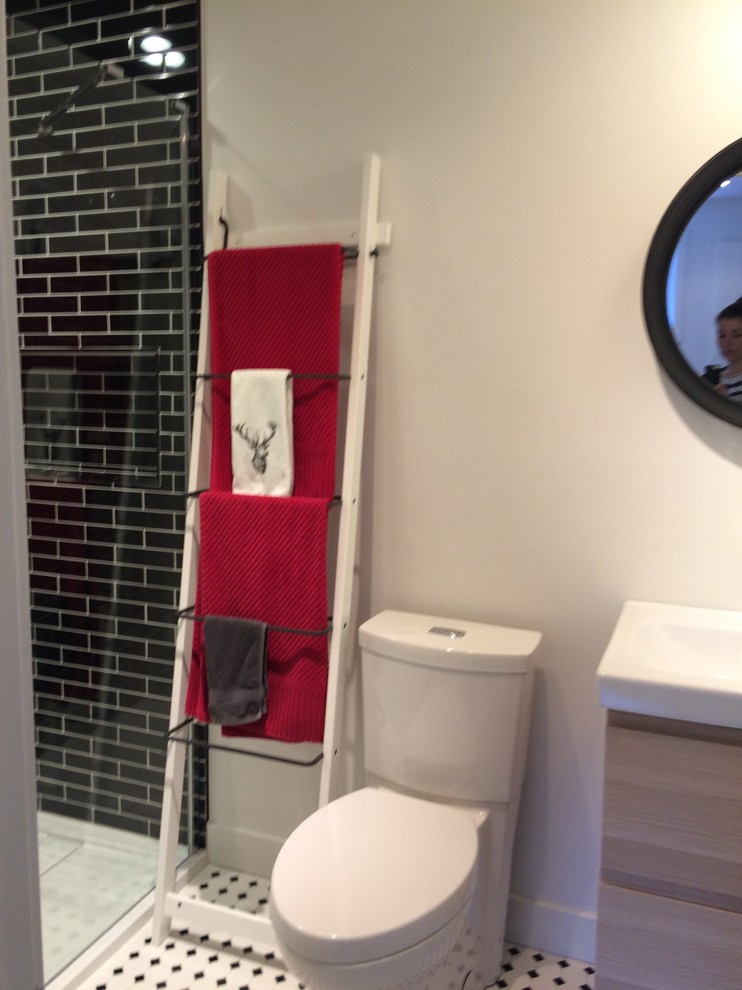 Aménagement d'une petite salle de bain moderne en bois clair avec un placard à porte plane, WC séparés, un carrelage noir et blanc, des carreaux de céramique, un mur blanc, un sol en carrelage de céramique, un lavabo intégré et un plan de toilette en surface solide.