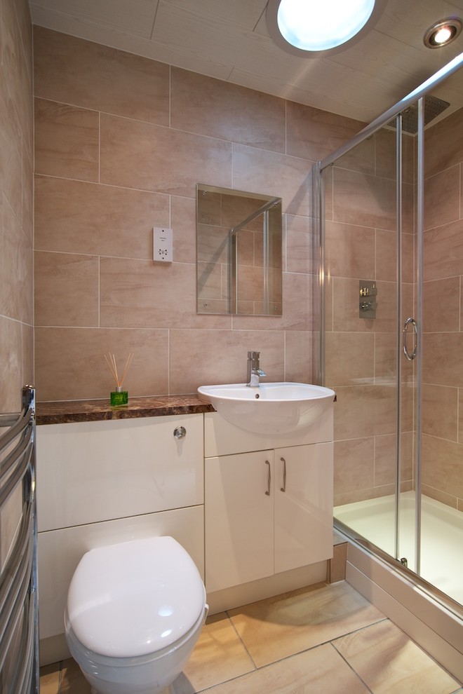 Photo of a small contemporary bathroom in Other with a console sink, flat-panel cabinets, white cabinets, a double shower, a wall mounted toilet, ceramic flooring, beige tiles, ceramic tiles and beige walls.