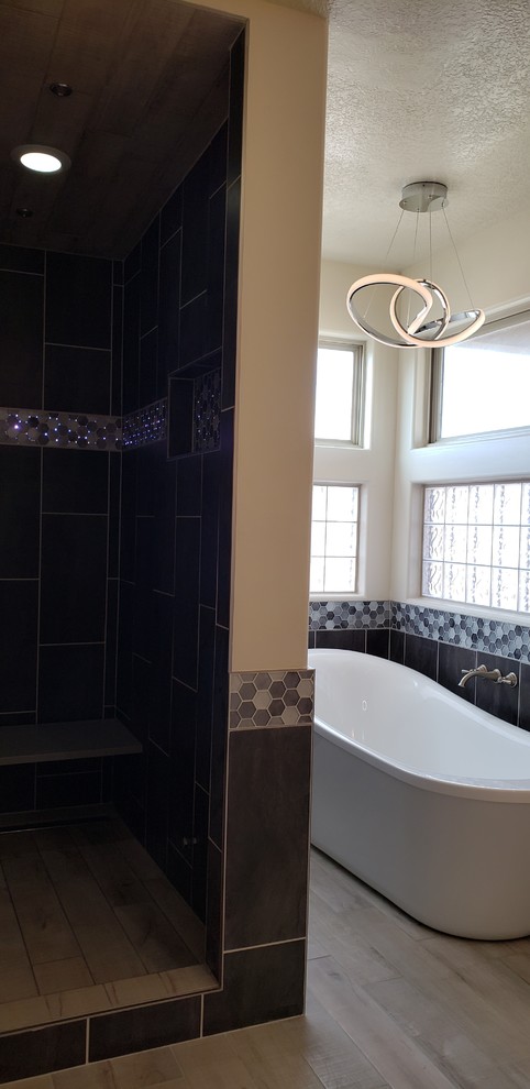 Идея дизайна: главная ванная комната среднего размера в современном стиле с отдельно стоящей ванной, душем в нише, серой плиткой, столешницей из кварцита и душем с распашными дверями
