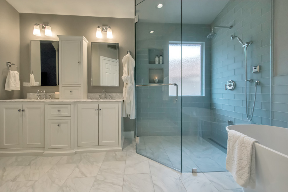 Inspiration för stora moderna en-suite badrum, med ett fristående badkar, en kantlös dusch, grå kakel, glaskakel, grå väggar, klinkergolv i porslin, vitt golv, dusch med gångjärnsdörr, luckor med infälld panel, vita skåp, ett undermonterad handfat och bänkskiva i kvarts