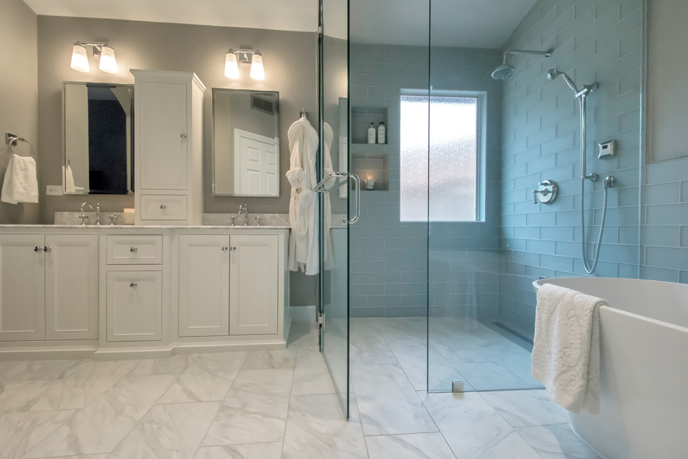 Idéer för stora funkis en-suite badrum, med ett fristående badkar, en kantlös dusch, grå kakel, glaskakel, grå väggar, klinkergolv i porslin, vitt golv, dusch med gångjärnsdörr, luckor med infälld panel, vita skåp, ett undermonterad handfat och bänkskiva i kvarts
