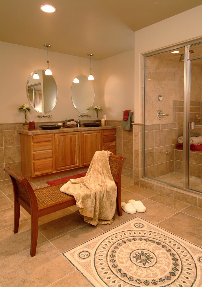 Réalisation d'une salle de bain principale tradition en bois clair de taille moyenne avec un placard avec porte à panneau surélevé, un espace douche bain, un carrelage beige, des carreaux de céramique, un mur beige, un sol en carrelage de céramique, une vasque et un plan de toilette en carrelage.