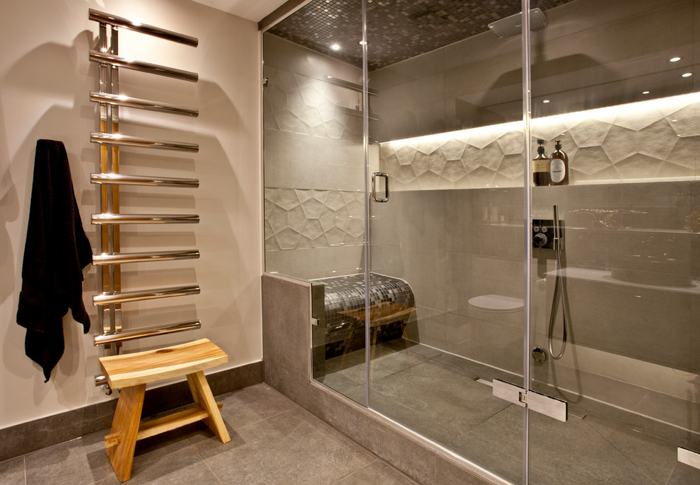 Foto på ett mellanstort funkis badrum, med en vägghängd toalettstol, grå kakel, porslinskakel, beige väggar, klinkergolv i porslin, ett fristående handfat och bänkskiva i akrylsten