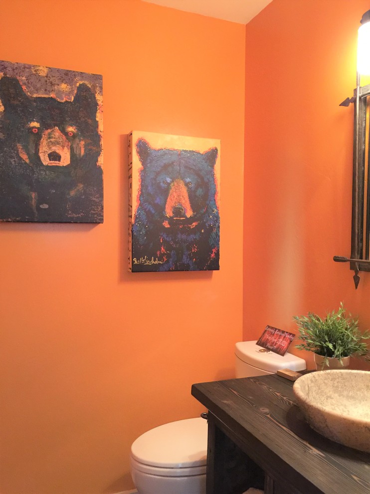 Mittelgroßes Rustikales Duschbad mit verzierten Schränken, braunen Schränken, Waschtisch aus Holz, Wandtoilette mit Spülkasten, oranger Wandfarbe, Aufsatzwaschbecken, braunem Holzboden und buntem Boden in San Francisco