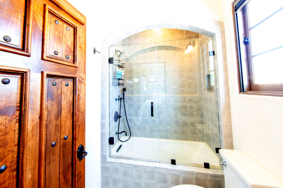 Bild på ett mellanstort medelhavsstil badrum för barn, med luckor med upphöjd panel, bruna skåp, ett badkar i en alkov, en dusch/badkar-kombination, grön kakel, keramikplattor, vita väggar, ett nedsänkt handfat, kaklad bänkskiva och dusch med gångjärnsdörr