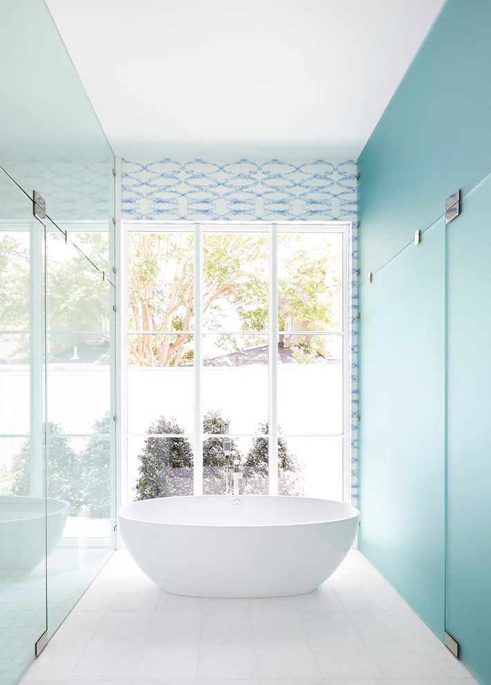 На фото: ванная комната в современном стиле с отдельно стоящей ванной, душем без бортиков и синими стенами с