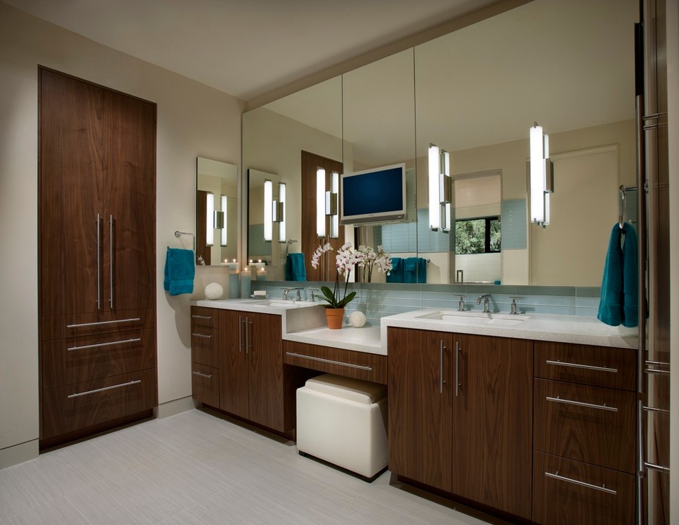 Inspiration pour une salle de bain design en bois foncé avec un lavabo encastré, un placard à porte plane et un carrelage gris.