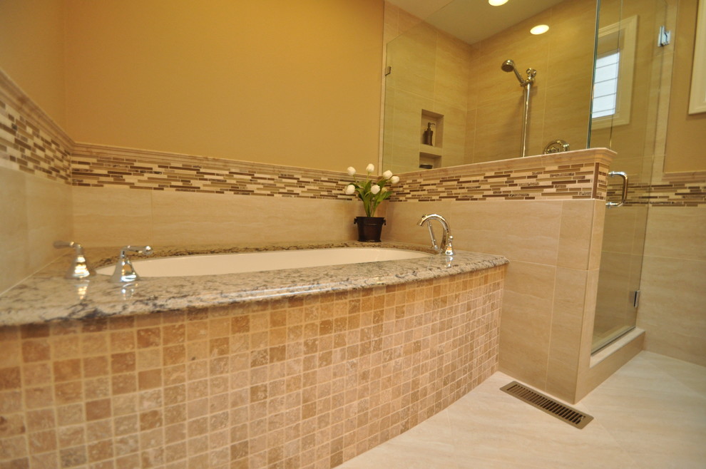 Mid-sized elegant master beige tile and porcelain tile porcelain tile corner shower photo in Seattle with an undermount sink, raised-panel cabinets, medium tone wood cabinets, granite countertops, an undermount tub, a two-piece toilet and beige walls