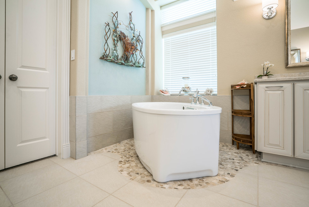Источник вдохновения для домашнего уюта: большая главная ванная комната в морском стиле с отдельно стоящей ванной, желтыми стенами и полом из керамической плитки