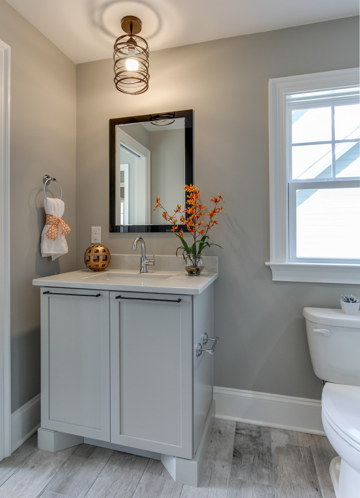 Diseño de cuarto de baño tradicional renovado pequeño con armarios con paneles empotrados, puertas de armario grises, aseo y ducha y encimera de cuarzo compacto