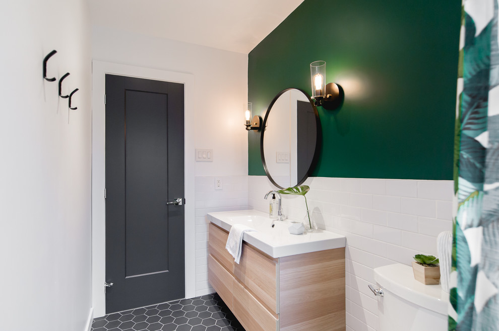 Exemple d'une salle d'eau moderne en bois clair avec un placard à porte plane, une baignoire en alcôve, un combiné douche/baignoire, WC à poser, un carrelage blanc, un mur vert, un sol en carrelage de céramique, un plan de toilette en quartz, un sol gris, un plan de toilette blanc, un carrelage métro et un plan vasque.