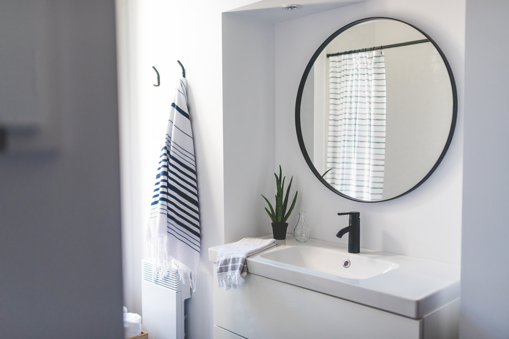Bathroom - mid-sized scandinavian 3/4 gray tile and porcelain tile ceramic tile bathroom idea in Montreal with flat-panel cabinets, white cabinets, a one-piece toilet, white walls, a wall-mount sink and quartzite countertops