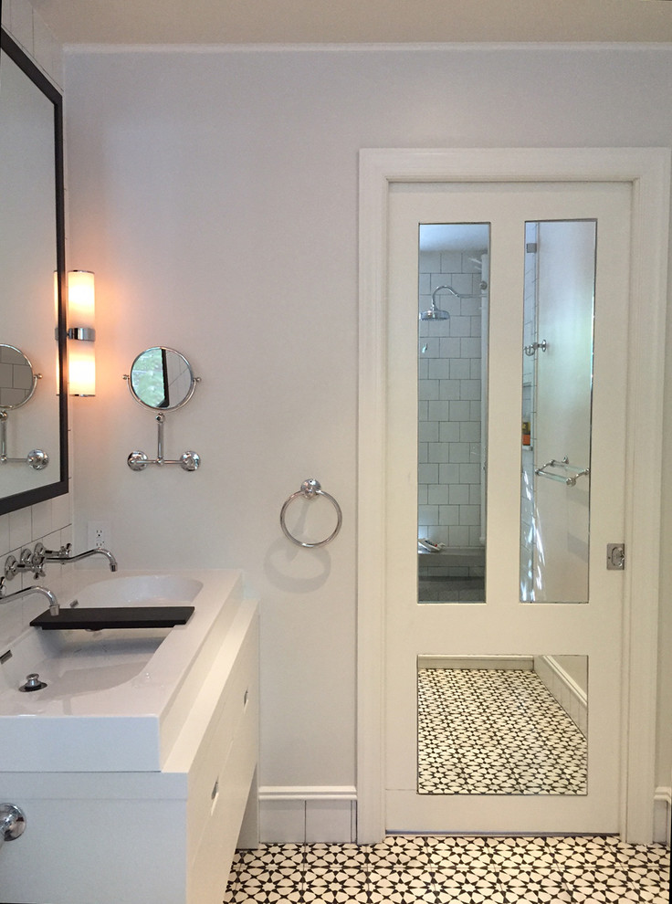 Inspiration for a mid-sized modern master white tile and ceramic tile cement tile floor bathroom remodel in New York with flat-panel cabinets, white cabinets, a bidet, white walls, solid surface countertops and a trough sink