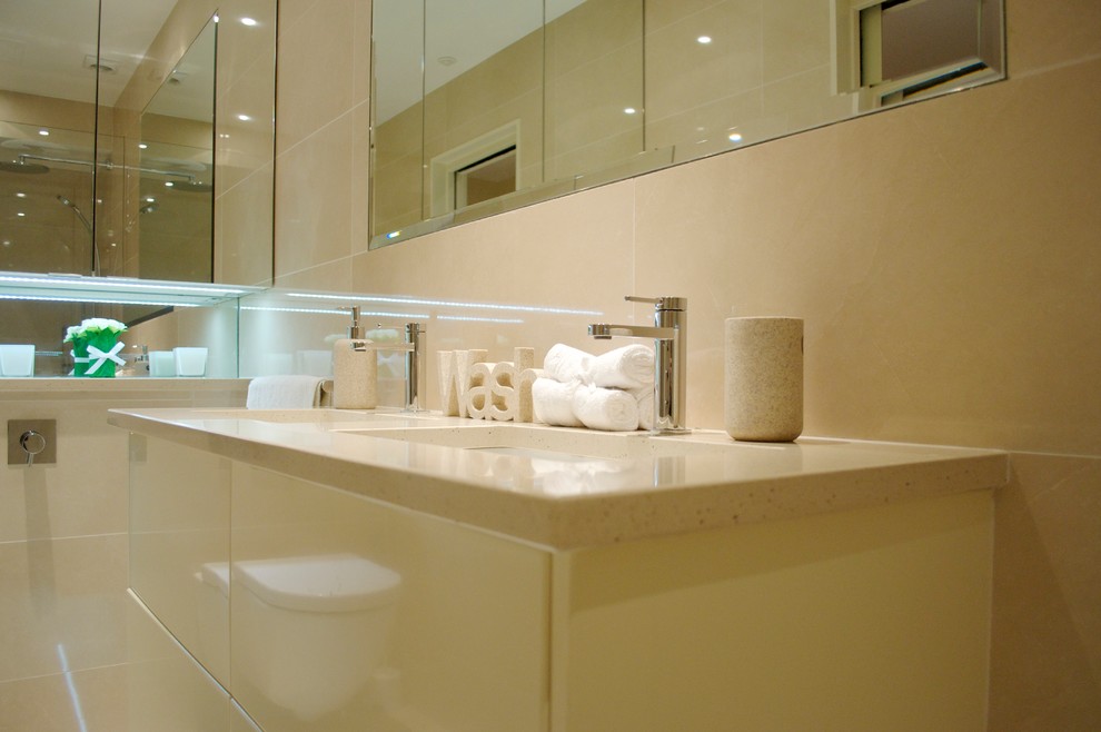 Photo of a small contemporary ensuite bathroom in London with beige cabinets, a walk-in shower, a wall mounted toilet, beige tiles, ceramic tiles, beige walls, ceramic flooring, a wall-mounted sink and granite worktops.
