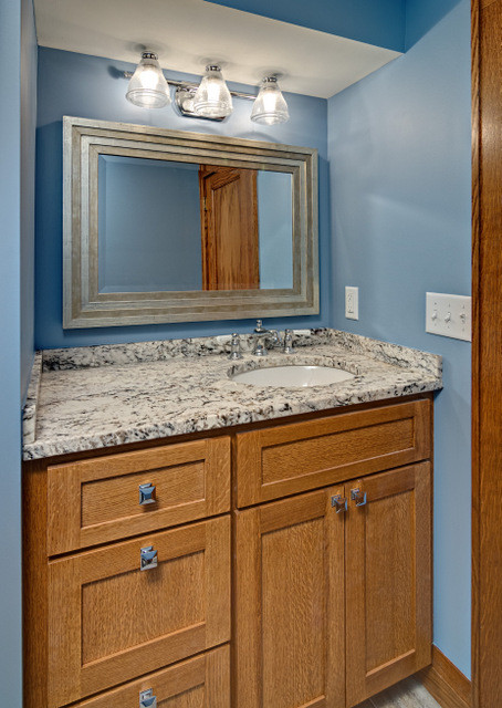 Immagine di una stanza da bagno tradizionale di medie dimensioni con ante in stile shaker, ante in legno scuro, pareti blu, lavabo sottopiano, top in granito e top multicolore