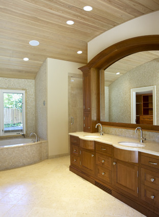 Example of a large classic master beige tile and stone tile travertine floor drop-in bathtub design in San Francisco with an undermount sink, dark wood cabinets, marble countertops, a two-piece toilet, beige walls and recessed-panel cabinets