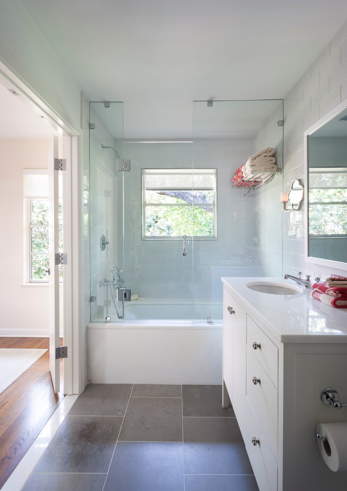 Inspiration for a timeless gray tile and stone tile tub/shower combo remodel in Austin with an undermount sink, white cabinets, an undermount tub and flat-panel cabinets