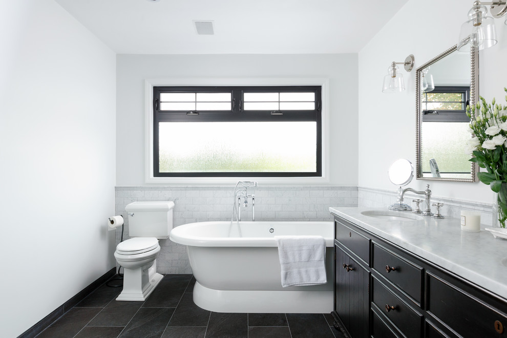 Стильный дизайн: главная ванная комната в классическом стиле с темными деревянными фасадами, отдельно стоящей ванной, раздельным унитазом, белыми стенами, врезной раковиной, серым полом, серой столешницей и плоскими фасадами - последний тренд