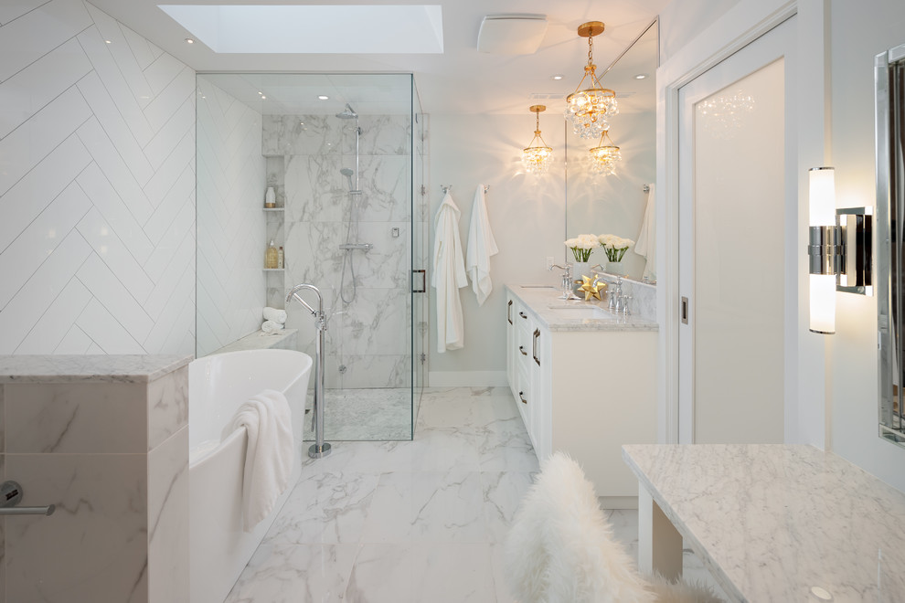 This is an example of a medium sized traditional ensuite bathroom in Vancouver with recessed-panel cabinets, white cabinets, a freestanding bath, a corner shower, a two-piece toilet, white tiles, porcelain tiles, grey walls, porcelain flooring, a submerged sink and marble worktops.