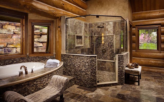 Cette image montre une grande salle de bain principale chalet avec un bain bouillonnant, une douche d'angle et un carrelage de pierre.