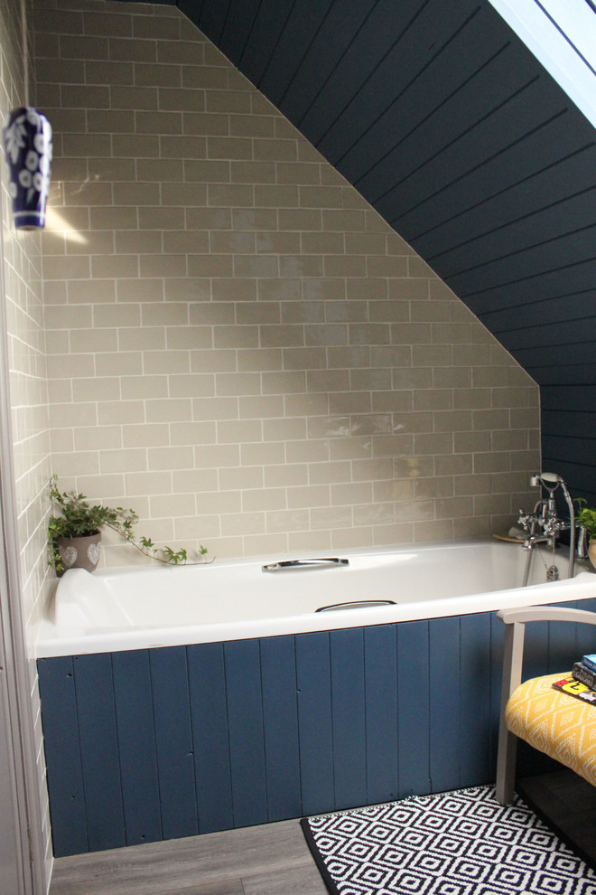 Small rural family bathroom in West Midlands with a built-in bath, a two-piece toilet, beige tiles, ceramic tiles, blue walls, laminate floors, a pedestal sink and grey floors.