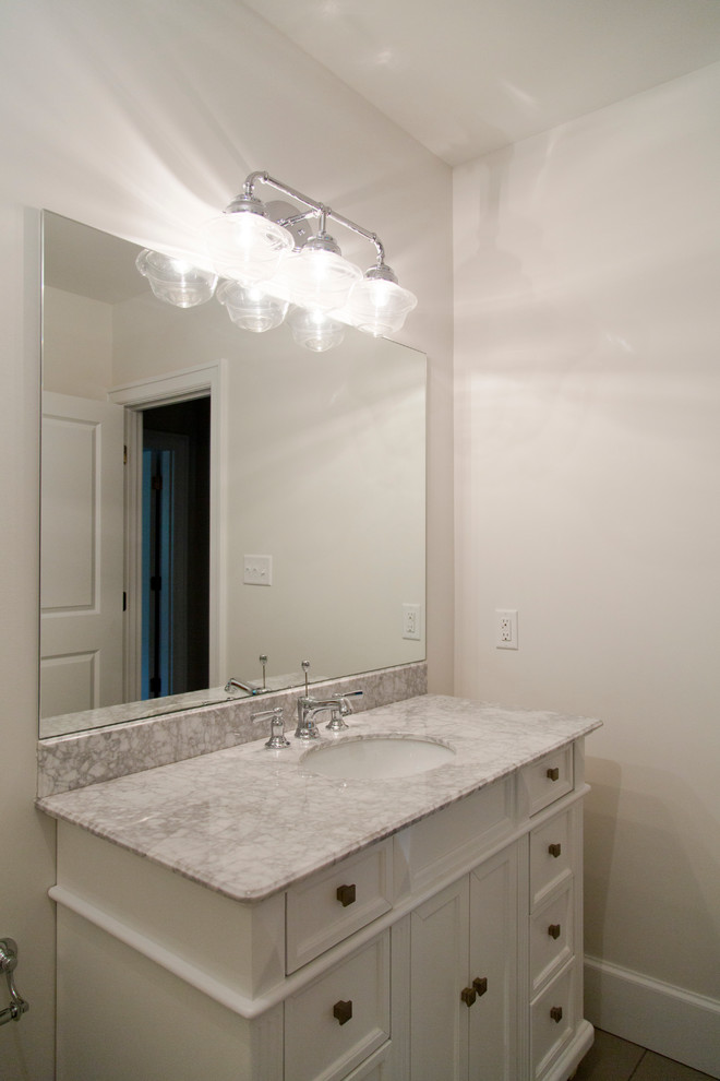 Cette image montre une petite salle de bain traditionnelle avec un placard en trompe-l'oeil, des portes de placard blanches, WC à poser, un carrelage gris, des carreaux de céramique, un mur blanc, un sol en carrelage de céramique, un lavabo intégré et un plan de toilette en granite.