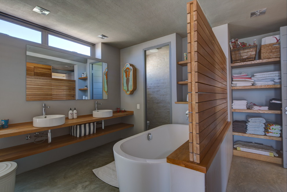 Idéer för ett maritimt badrum, med ett fristående handfat, öppna hyllor och ett fristående badkar