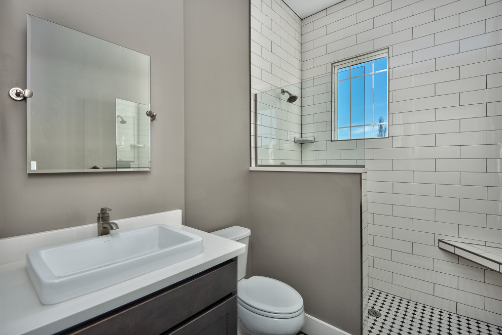 Idéer för att renovera ett litet funkis vit vitt badrum med dusch, med luckor med infälld panel, skåp i mörkt trä, en dusch i en alkov, en toalettstol med separat cisternkåpa, vit kakel, porslinskakel, grå väggar, mosaikgolv, ett nedsänkt handfat, laminatbänkskiva, flerfärgat golv och med dusch som är öppen