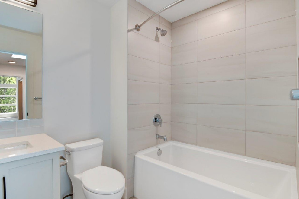 Example of a small minimalist white tile and subway tile ceramic tile, white floor and single-sink bathroom design in Other with recessed-panel cabinets, white cabinets, a one-piece toilet, white walls, an undermount sink, solid surface countertops, white countertops and a built-in vanity