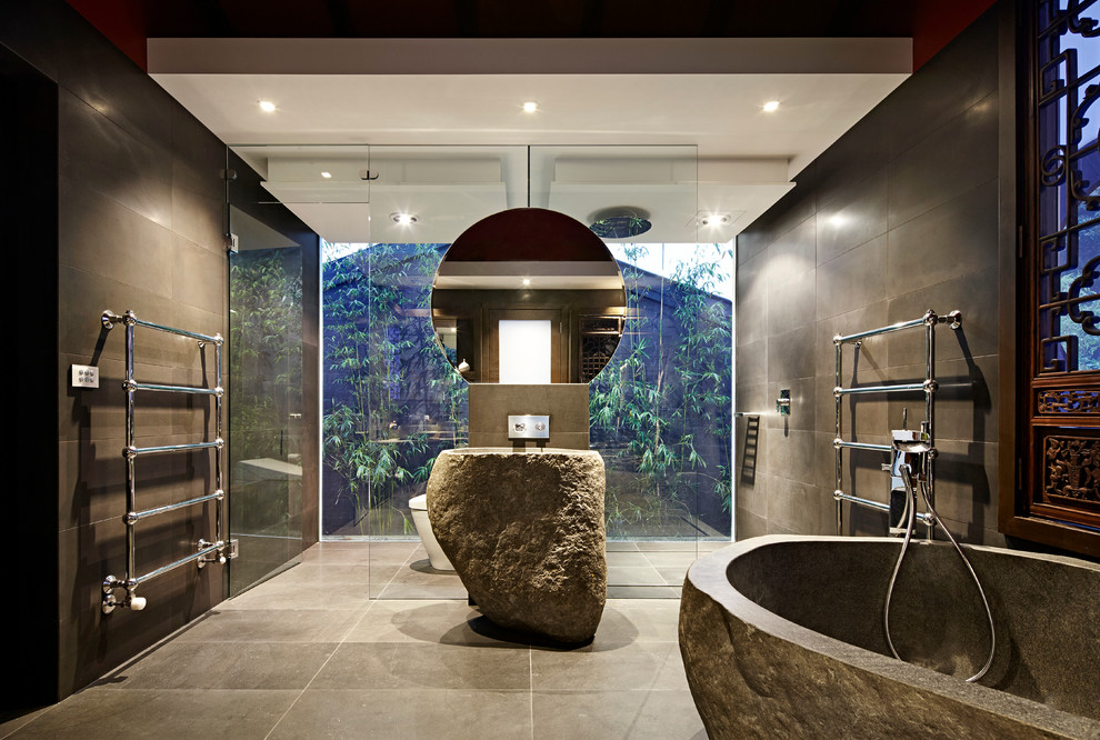 Ispirazione per una grande stanza da bagno etnica con vasca freestanding, piastrelle marroni e lavabo a colonna
