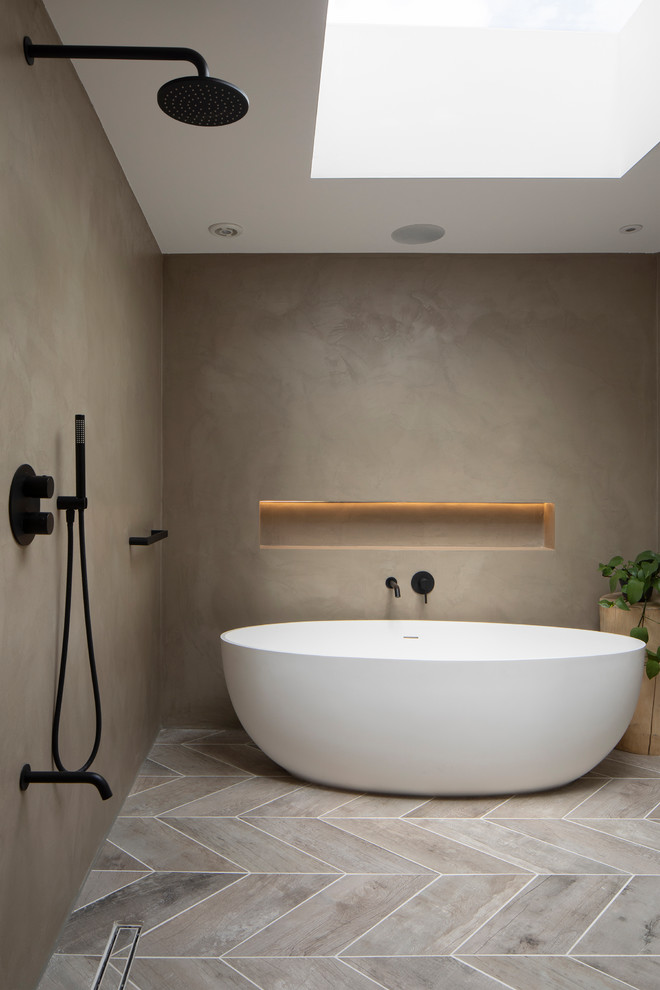 Design ideas for an eclectic wet room bathroom in London with flat-panel cabinets, grey cabinets, a freestanding bath, a wall mounted toilet, grey walls, porcelain flooring, a built-in sink, concrete worktops, grey floors, an open shower and grey worktops.