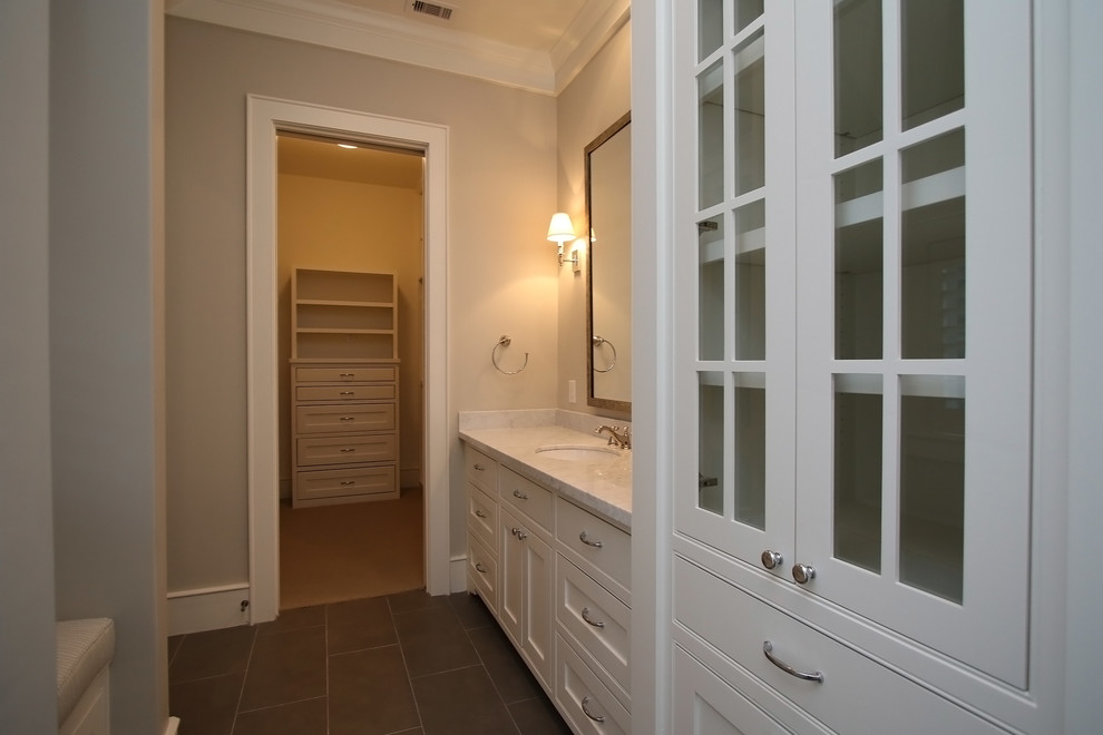Immagine di una grande stanza da bagno padronale tradizionale con ante a filo, vasca sottopiano, doccia alcova, pavimento in marmo, lavabo da incasso e top in pietra calcarea