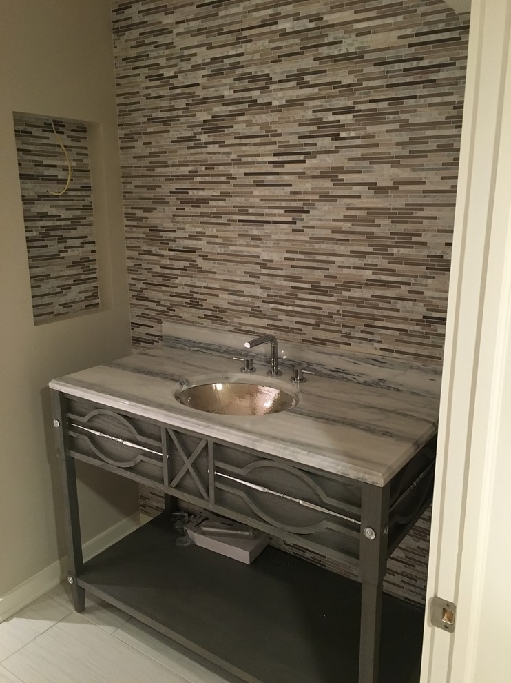 Immagine di una stanza da bagno contemporanea con nessun'anta, ante grigie, piastrelle grigie, piastrelle a listelli, pareti beige, pavimento in gres porcellanato e lavabo sottopiano