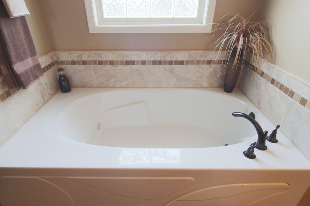 Foto di una stanza da bagno padronale tradizionale di medie dimensioni con vasca ad alcova e pareti beige