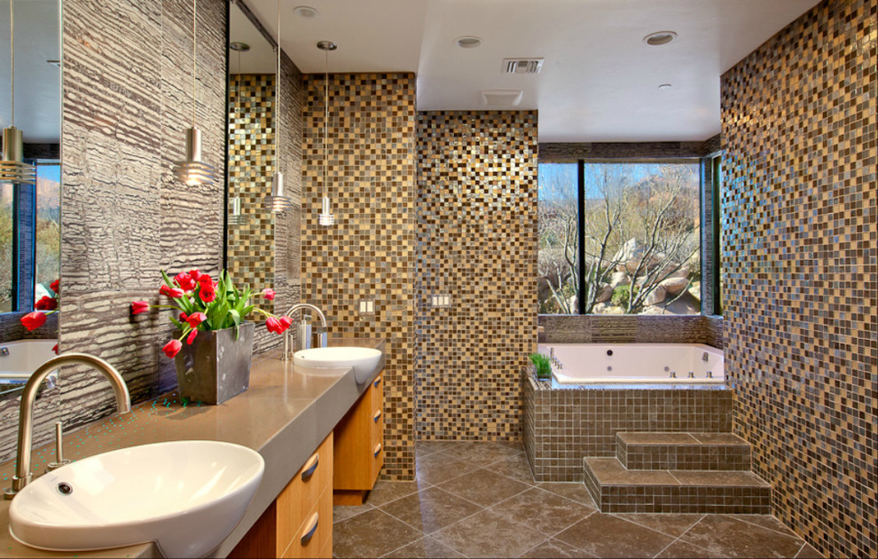 Exemple d'une salle de bain principale tendance avec un placard à porte plane, des portes de placard marrons, un bain bouillonnant, un carrelage multicolore, mosaïque, un mur marron, un lavabo posé et un sol marron.