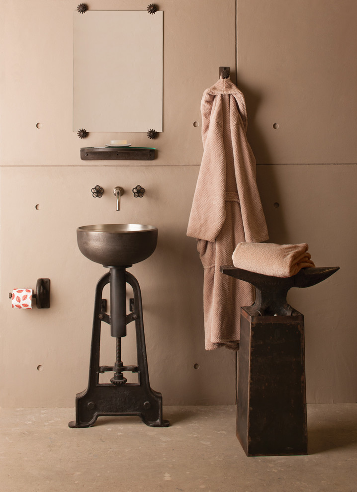 Example of an urban concrete floor bathroom design in Detroit with beige walls and a pedestal sink