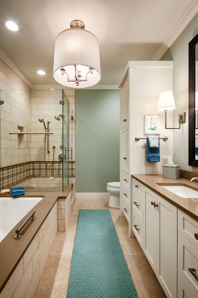 На фото: ванная комната среднего размера в классическом стиле с врезной раковиной, фасадами в стиле шейкер, белыми фасадами, полновстраиваемой ванной, угловым душем, бежевой плиткой, раздельным унитазом, каменной плиткой, зелеными стенами, столешницей из искусственного кварца, коричневым полом и душем с распашными дверями