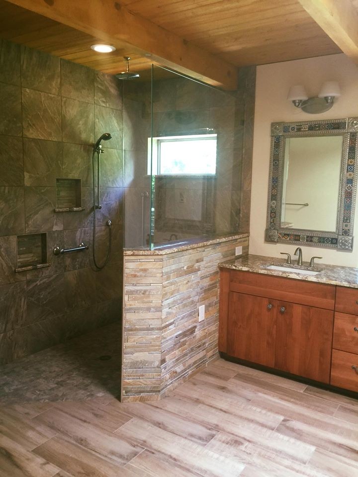 Cette photo montre une salle de bain principale montagne en bois brun de taille moyenne avec un placard à porte plane, une baignoire posée, une douche ouverte, WC à poser, un carrelage beige, un carrelage blanc, des dalles de pierre, un mur beige, parquet clair, un lavabo posé et un plan de toilette en surface solide.