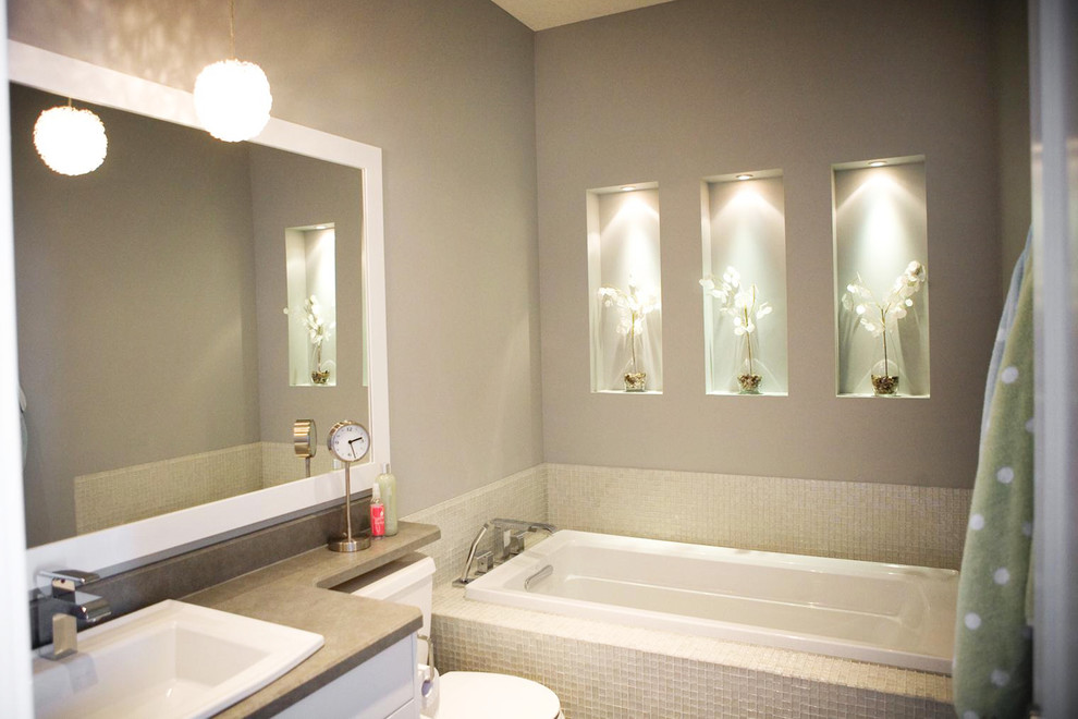 Klassisches Badezimmer mit Einbauwaschbecken, flächenbündigen Schrankfronten, weißen Schränken, Quarzit-Waschtisch, grauen Fliesen und Glasfliesen in Sonstige