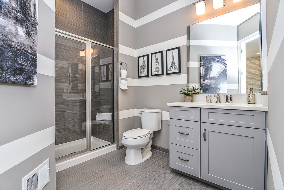 Inspiration for a medium sized traditional shower room bathroom in DC Metro with shaker cabinets, grey cabinets, an alcove shower, a two-piece toilet, grey tiles, porcelain tiles, multi-coloured walls, slate flooring, a submerged sink and quartz worktops.
