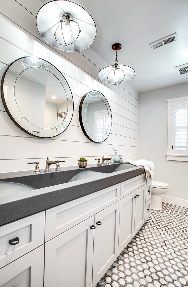 Imagen de cuarto de baño marinero grande con armarios estilo shaker, puertas de armario blancas, baldosas y/o azulejos blancos, paredes blancas, encimera de esteatita, encimeras grises y lavabo de seno grande