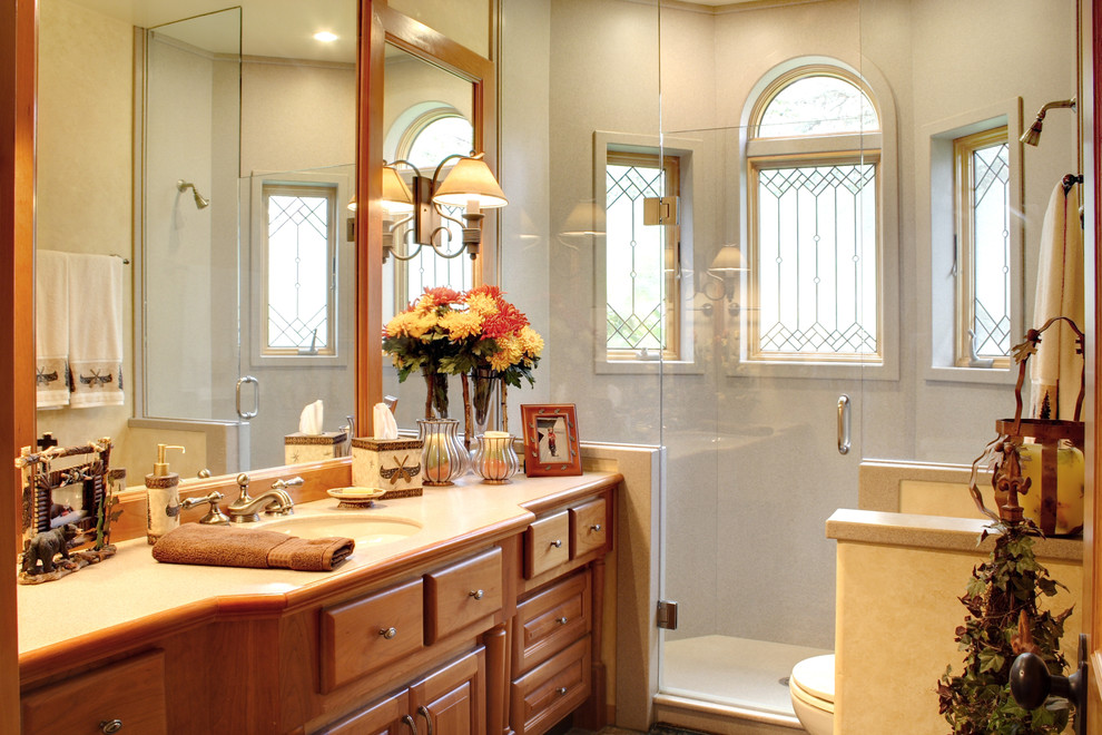 Klassisk inredning av ett mellanstort badrum, med ett undermonterad handfat, möbel-liknande och skåp i mellenmörkt trä